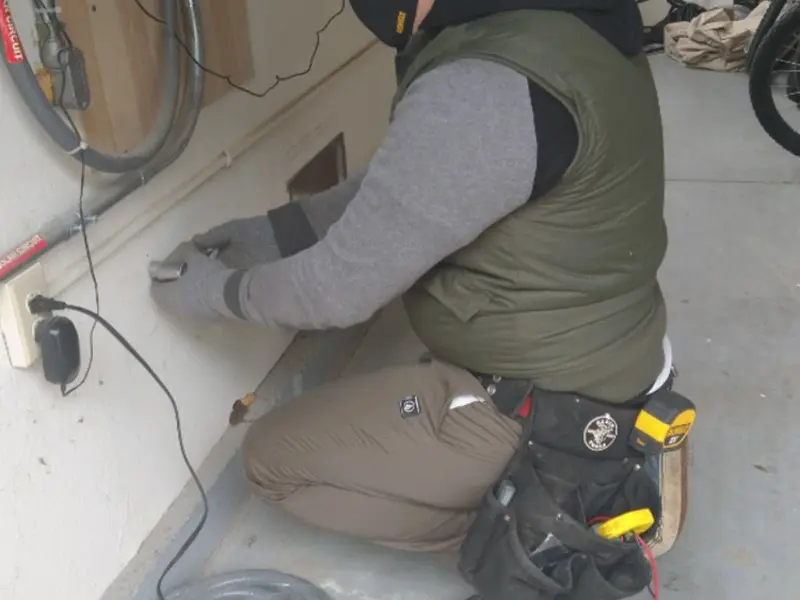 Electrician performing outlet wiring in a Donaldsonville garage